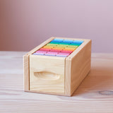Die sechzig bunten Holzbausteine von Glückskäfer in ihrer Holzbox sortiert. Die Öffnung zum Schieben ist gut zu sehen.