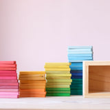 Die 60 bunten Holzbausteine von Glückskäfer sind in vier Stapeln nebeneinander sortiert aufgestellt.