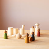 Kleine Holzdosen, mit Deckel oder ohne, Spielfiguren aus Holz in Erdtönen und zwei kleine Pilz Holzfiguren stehen zusammen oder übereinander.