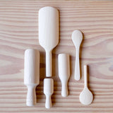 Das 6er-Set Holzlöffeln und Holzschaufeln von Kokomoo: alle sechs verschieden geformten und größere und kleine Holzlöffeln sind nebeneinander aufgelegt, von der Rückseite zu sehen.