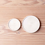 Zwei kleine Holzteller aus Ahornholz, unterschiedliche Größen, liegen nebeneinander.