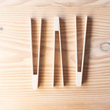 Drei Stück Holzzangen von Kokomoo aufgelegt nebeneinander.