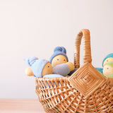 Im kleinen Kinderkorb aus Weide sitzen vier Wichtel Stoffpuppen von Nanchen.