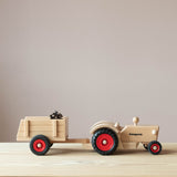Kleiner Spielzeuganhänger aus Holz von Fagus angehängt am Traktor.