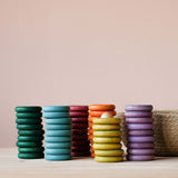 Die Holzringe und Holzplättchen Grapat "Nins, Rings & Coins" Holzfiguren Spielset nebeneinander aufgestapelt.