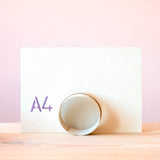 Eine Vorderansicht eines aufgestellten Holzsiebes vor einer A4 großen Tafel.