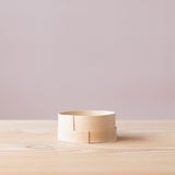 Seitenansicht eines aus Holz gefertigten Siebes.