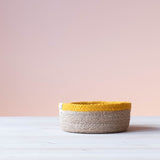 Man sieht den Jutekorb von der Seite - unten naturfarben, der obere Rand ist gelb