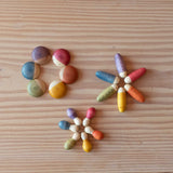 Die 18 verschiedenen Spielmaterialien Grapat "Insects" kleine Krabbeltiere aus Holz zum Spielen in drei Kreise aufgelegt.