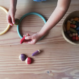 Kinderhände bespielen Grapat "Insects" kleine Krabbeltiere Spielmaterialien aus Holz und bunte Motorikringe.