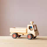 Der LKW-Kipper von Fagus aus Holz, seitlich zu sehen, im Führerhaus die beiden passenden Holzfiguren.
