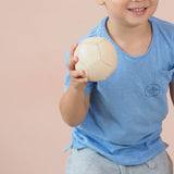 Ein Kind hält den kleinen Lederball von Lautenbach, der einen Durchmesser von 9 cm hat, in der Hand.