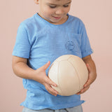 Ein Kind hält den großen Lederball von Lautenbach, der einen Durchmesser von 14 cm hat, mit beiden Händen.