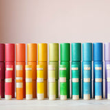 Alle Teile des Lola Sets von Grapat aufgestapelt, Lolas in drei verschiedenen Größen und 12 verschiedenen Farben, dahinter die 36 Becher in den 12 verschiedenen Farben.