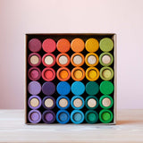 Das Spielmaterial Lola von Grapat in zwölf Farben des Regenbogens sortiert in der Verpackung.