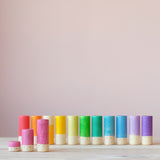 Elf Lola Spielfiguren aus Holz von Grapat in einer Reihe, nur die rosa farbene Lola steht davor mit den beiden kleineren Lolas.