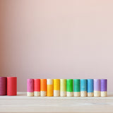 Alle zwölf großen Lola Spielfiguren von Grapat in einer Reihe farblich sortiert.