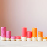 Die rosa, roten und orangen Lolas von Grapat in drei verschiedenen Größen farblich sortiert in einer Reihe.