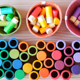 Lola von Grapat: die Spielfiguren liegen in Körbchen, die Becher, Röhren und Zylinder stehen davor.