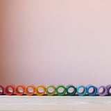 Die bunten Röhren aus Holz vom Grapat Spielmaterial Lola aufgereiht, farblich sortiert.