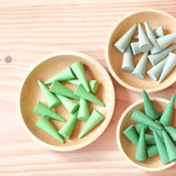 Drei kleine Holzteller gefüllt mit Grapat "Green Cone" - grüne Mandala Steine in Kegelform.