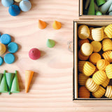 Verschiedene Mandala Legematerialien liegen schon zu Kunstwerken sortiert, daneben eine Schachtel mit Mandala Honigwaben von Grapat in gelb.