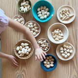 Die 120 Mandalasteine aus Holz sind nach ihren Formen in zehn verschiedenen Holzschalen und Körbchen sortiert.