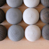 Nahaufnahme der Grapat Mandala Steine, die verschiedenen Grautöne sind gut zu sehen und die Holzmaserung scheint durch die Farbe.