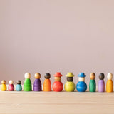 Die zwölf verschiedenen Grapat "Together" Menschenkinder Spielfiguren aus Holz alle in einer Reihe aufgestellt.