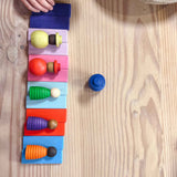 5 Holzfiguren der Grapat "Together" Menschenkinder liegen auf bunten Holzbausteinen.