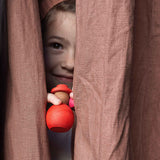 Ein Kind schaut durch einen Vorhang durch und hat zwei Grapat Nins "Together" in der Hand.