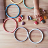 Die Motorikringe in Pastellfarben liegen auf dem Boden, dazwischen Grapat "Insects" kleine Krabbeltiere Spielfiguren.