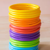 24er-Set Motorikringe in sechs Regenbogenfarben aufeinander gestapelt.