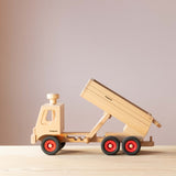 Der Fagus LKW Muldenkipper aus Holz seitlich, in die linke Fahrtrichtung, die Muldenkippe ist in der dritten Position, also in der steilsten Position und hinten öffnet sich schon die Mulde zum Abkippen.