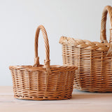 Der ganz kleine Korb von Kokomoo, ein Körbchen für Kleinkinder zum Spielen, mit Henkel, steht vor einem großen Korb.