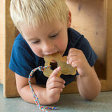 Ein Kleinkind liegt am Bauch und knabbert am Beißring von Hevea in Panda Form aus 100% Naturkautschuk.