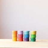 Coins von Grapat in Regenbogenfarben: die bunten 36 Holzplättchen sind nach Farben sortiert, 4 Stapel mit je 9 Plättchen und 3 Farben.