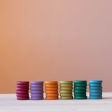 Coins von Grapat in Erdtönen: die farbigen 36 Holzplättchen sind nach Farben sortiert, je ein Stapel mit 6 Plättchen nebeneinander.