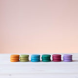 Coins von Grapat in Erdtönen: die farbigen 18 Holzplättchen sind nach Farben sortiert, je ein Stapel mit 3 Plättchen nebeneinander.