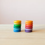 Coins von Grapat in Regenbogenfarben: die 12 unterschiedlichen Farben sind sortiert in zwei Stapeln von je 6 Holzplättchen zu sehen.