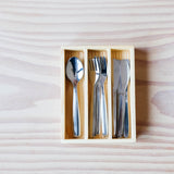 Kinderbesteck oder Puppenbesteck aus Edelstahl liegen im Holzkasten, drei Fächer für je 4 Löffeln ganz links, 4 Gabeln in der Mitte und 4 Messer rechts.