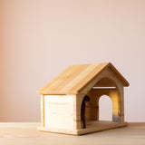 Holzstall für das Bauernhof Spiel von Drei Blätter von seitlich, ein kleines Pferd aus Filz schaut raus.