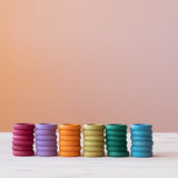 36 Stück Grapat "Rings" Holzringe in Erdtönen sind farblich sortiert zu je sechs Ringen gestapelt nebeneinander aufgestellt.