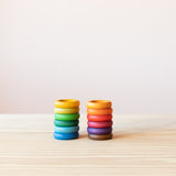 Bunte Holzringe passend zum Jahreskreis, angelehnt an die Waldorf Pädagogik Farben, in zwei Stapeln zu je sechs Ringen nebeneinander.