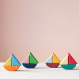 Das Grimms Schaukelschiffe Steckspiel Set für Babys ab 1 Jahr in bunten Farben: vier kleine Schiffe aus Holzbausteinen bunt zusammen gesteckt.