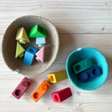 Die einzelnen Baustein-Teile des Grimms Schaukelschiffe Steckspiel Sets für Babys ab 1 Jahr liegen in Körben und rundherum bereit zum Spielen, das Stecksystem ist gut zu erkennen.