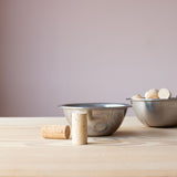 Zwei Schüsseln aus Edelstahl, eine leer, eine gefüllt mit Korken. Ein Korken liegt, einer steht vor der vorderen Schüssel, so kann man erkennen, dass die Höhe der Schüssel fast ident mit der Höhe des Flaschenkorkens ist.