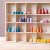 Im aufgestellten Tinker Tray Setzkasten von Grapat aus Holz stehen Mandalas aus Holz in verschiedenen bunten Farben und Formen in den Fächern.