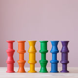 16 Stück Grapat "Spools" Spulen aus Holz, in 6 bunten Regenbogenfarben und drei unterschiedlichen Formen aufeinander gestapelt und nebeneinander aufgereiht.