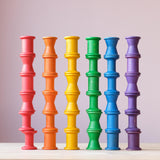 36 Stück Grapat "Spools" Spulen aus Holz, in 6 bunten Regenbogenfarben und drei unterschiedlichen Formen aufeinander gestapelt und nebeneinander aufgereiht.
